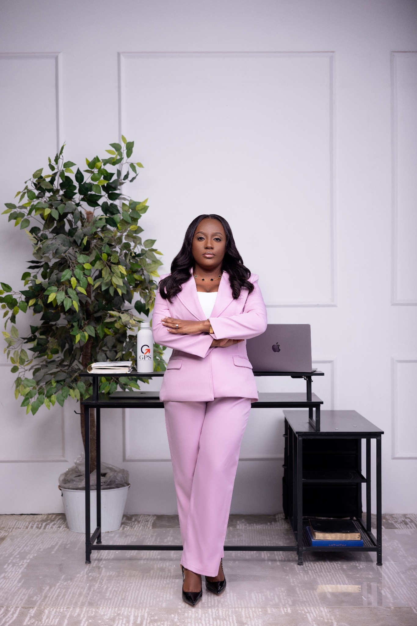 Dr. Nascine Brown in a pink suit standing in her GPS workspace