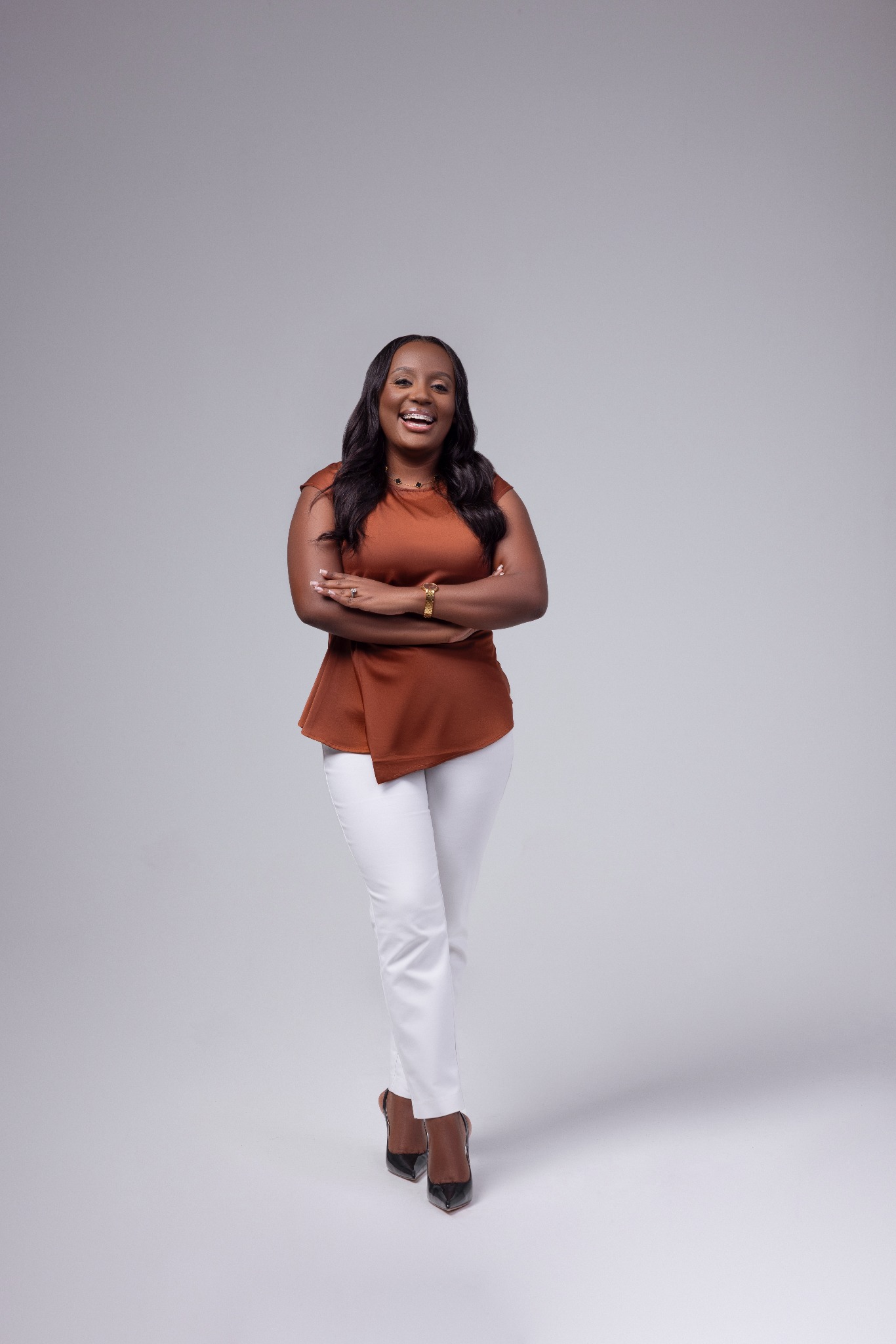 Dr. Nascine Brown in a terracotta top and white trousers